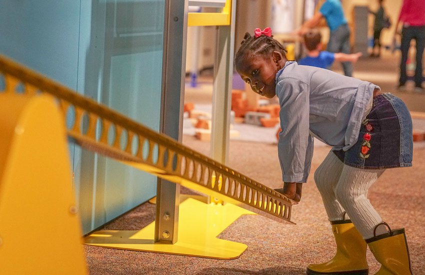 Child tests leverage on bright yellow leaver in the exhibition Science Unplugged