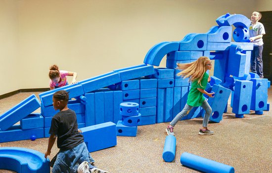 Children play in royal blue colored design foam pit in the exhibition Science Unplugged