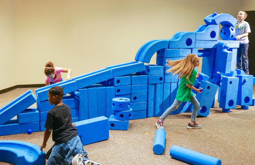 Children play in royal blue colored design foam pit in the exhibition Science Unplugged