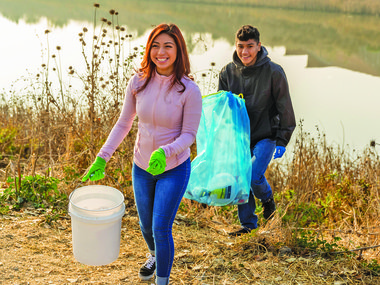 Group picks up trash along the river on a fall day