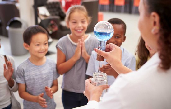 A group of kids watching a science experiment