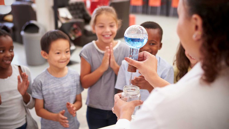 A group of kids watching a science experiment