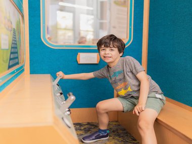 young guest engaging a lever in Crescent Crossing.jpg