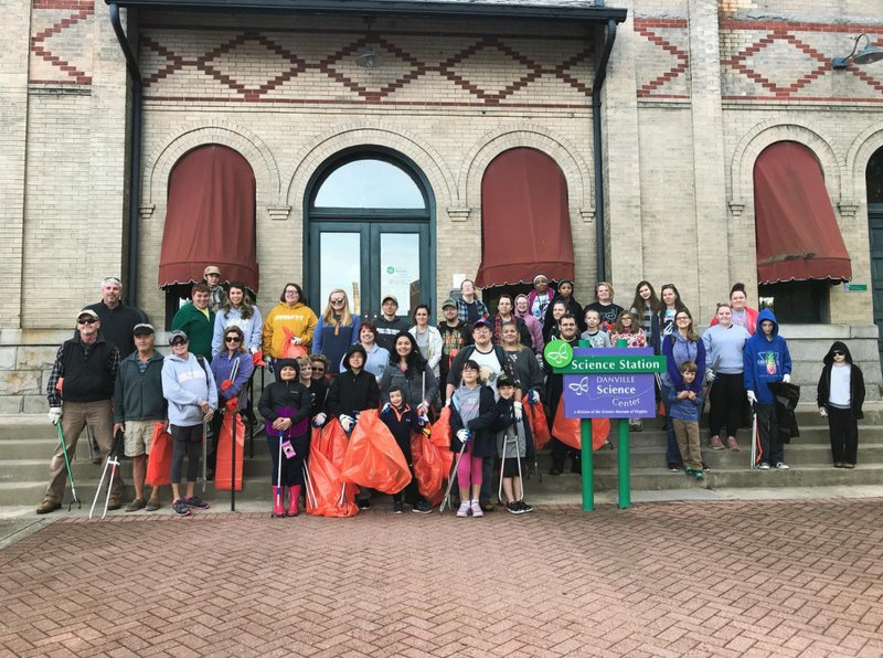 Guests on the steps of the train station ready to pick up trash